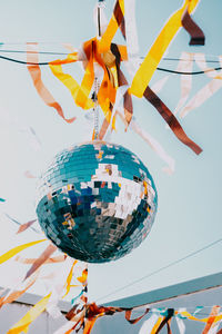 Disco ball on a background of blue sky. low angle view of decoration hanging on ceiling