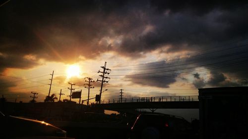 Car on road against cloudy sky at sunset