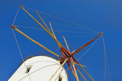 Low angle view of traditional windmill against clear blue sky