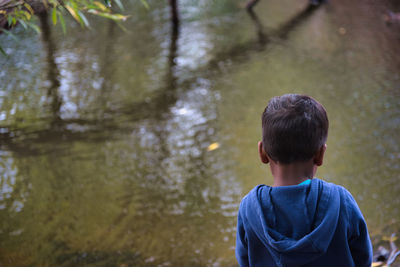 Rear view of boy standing in water