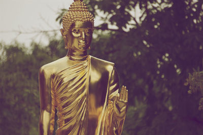 Statue of buddha against plants