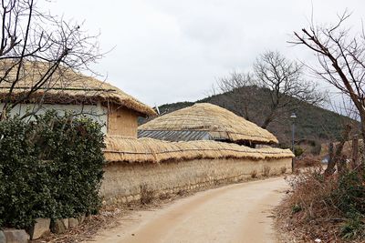 Houses by road against sky