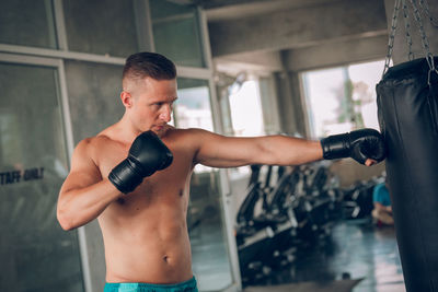 Shirtless boxer practicing boxing