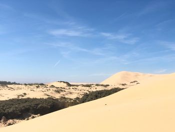 Scenic view of desert against blue sky