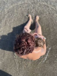 Cropped hand of woman standing at beach