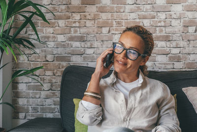 Smiling woman talking on phone at home