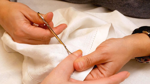 Cropped hands of woman performing manicure on female customer on table