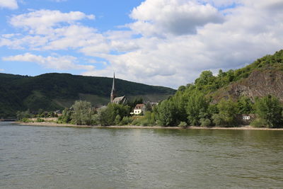 Scenic view of lake by buildings against sky