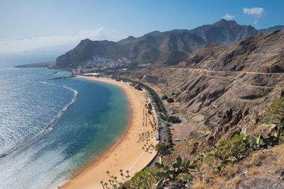 Scenic view of sea and mountains against sky