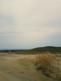 Scenic view of sand dunes against sky