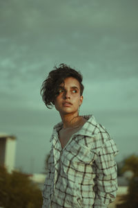 Portrait of young man standing against sky