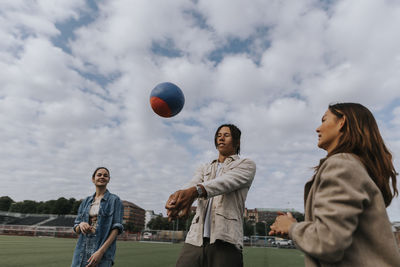 Smiling teenagers playing ball together