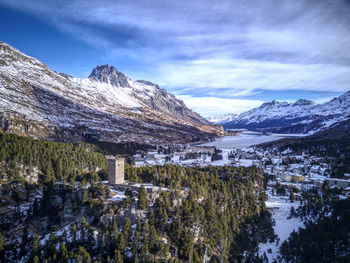 Scenic view of frozen lake by snowcapped mountains against sky