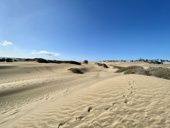 Scenic view of desert against clear blue sky