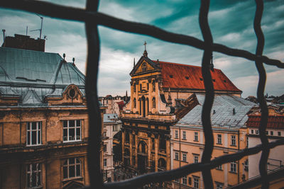 Buildings in city against cloudy sky