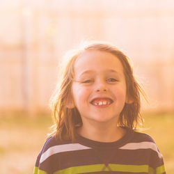 Close up of happy smiling boy outside facing camera