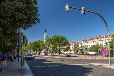 Street amidst trees and buildings against sky