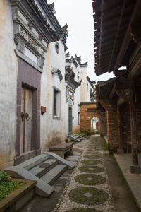 Alley amidst buildings in city against sky