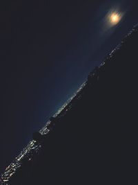 Low angle view of illuminated lights against clear sky at night