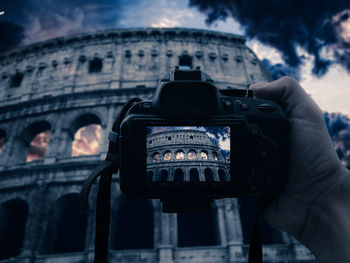 Midsection of man photographing against building