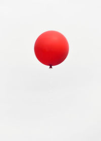 Low angle view of red balloon flying against clear sky during party