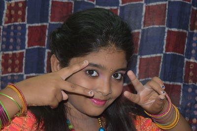 Close-up portrait of smiling girl gesturing at home