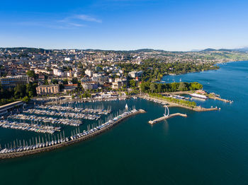 High angle view of city by sea against sky