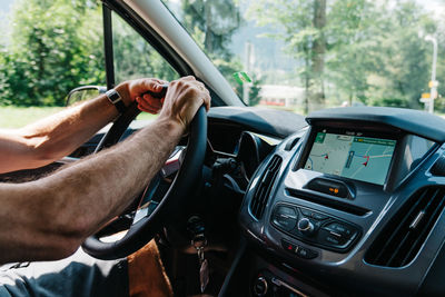 Cropped hands of man driving car