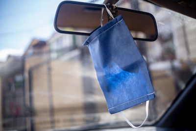 Mask hanging from the rear view mirror on the dashboard of the car, in the window you can view 