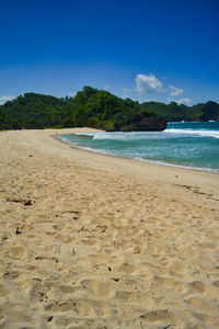 Scenic view of beach against blue sky