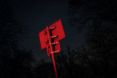 Low angle view of road sign against sky at night