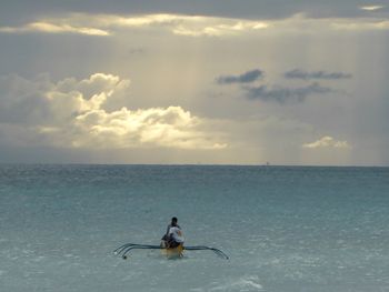 Man surfing in sea against sky