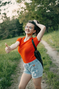 Portrait of smiling young woman standing on field