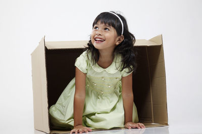 Portrait of smiling girl sitting in box