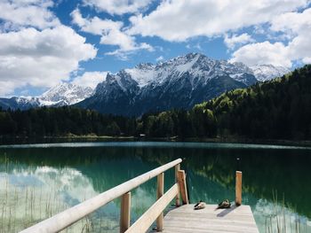 Scenic view of lake by snowcapped mountains against sky