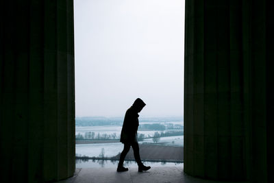 Side view of silhouette man standing in snow