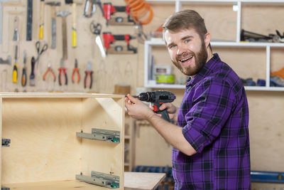 Portrait of smiling young man holding camera