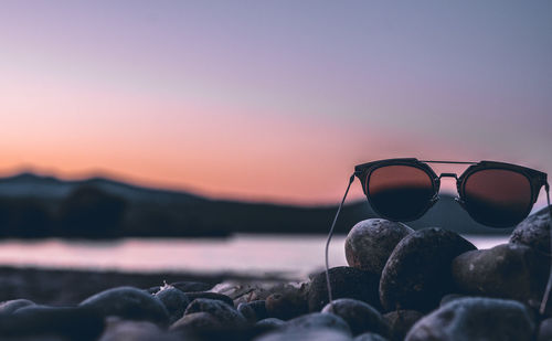 Close-up of rocks on beach against sky during sunset