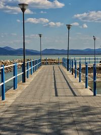 Pier on beach against sky