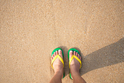 Low section of child in flip-flop standing at shore
