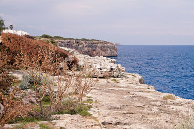 Rock formations by sea against sky