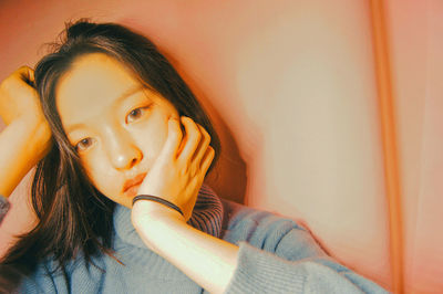 Close-up portrait of young woman against wall