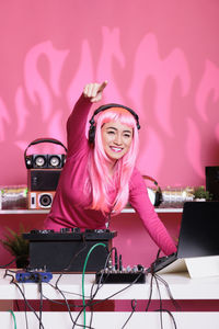 Portrait of young woman using mobile phone while sitting on stage