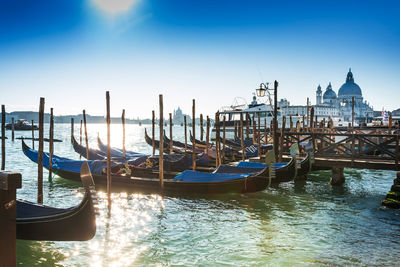 Gondolas moored on grand canal against sky