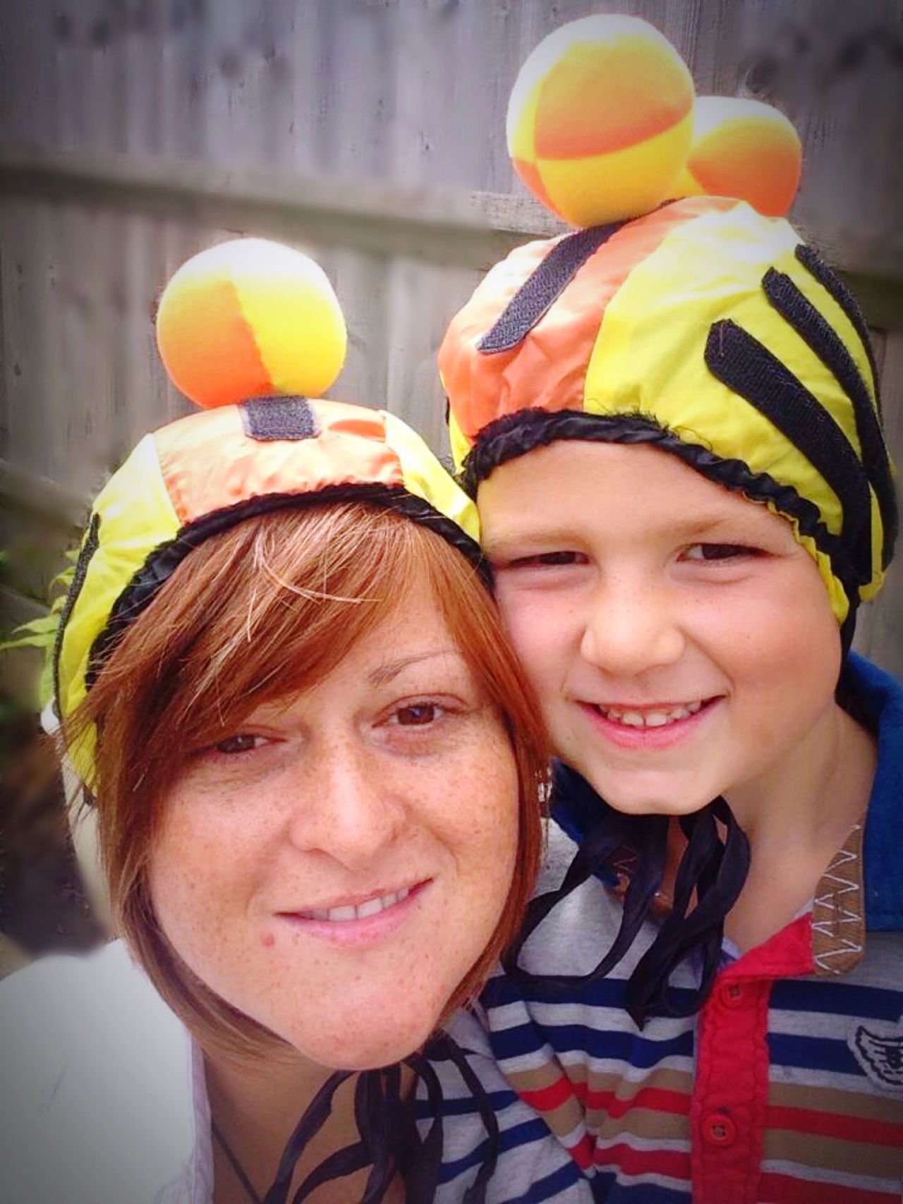 Mother and son looking at the camera with a ball game attached to their heads