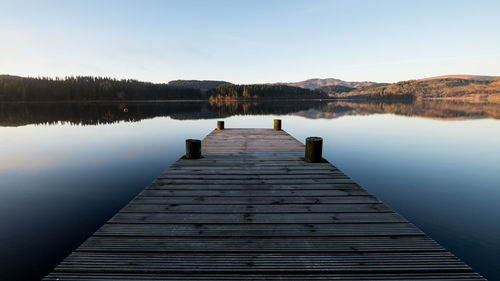 Pier over lake against clear sky