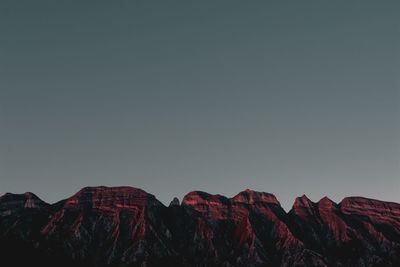 Scenic view of mountains against clear sky at dusk