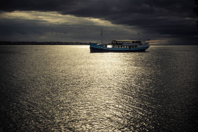 Boat sailing on sea against sky during sunset