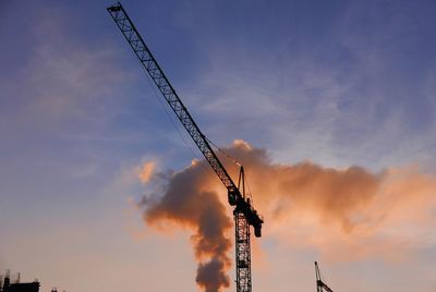Low angle view of electricity pylon against sky during sunset