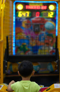 Rear view of boy looking at camera